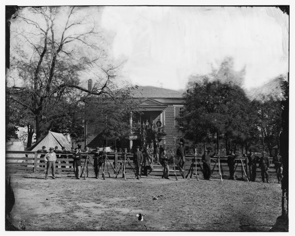 Federal soldiers and some civilians pose for a photograph in front of the building that gave Appomattox Court House its name. Click to enlarge (Library of Congress).